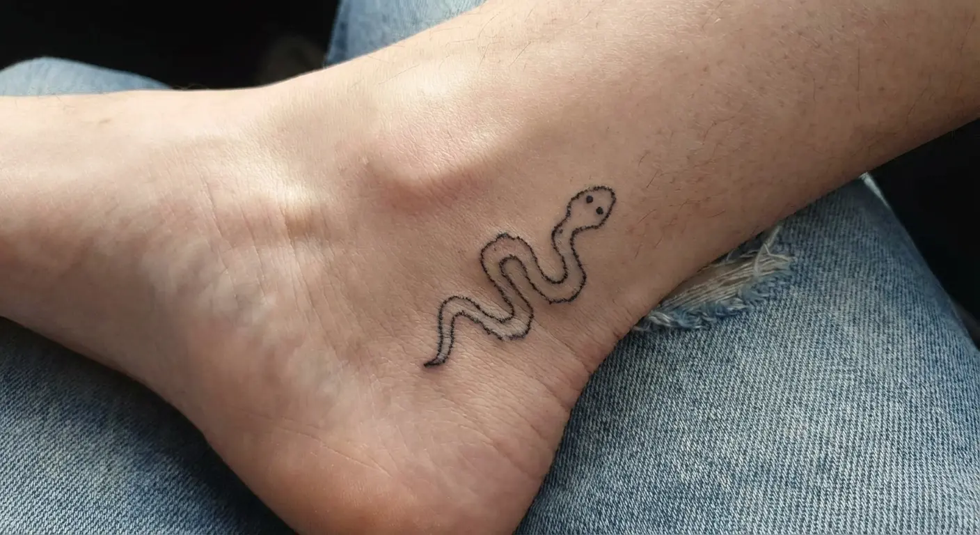 Squiggly snake ignorant style tattoo